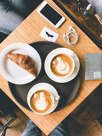 A cozy morning breakfast basket next to a smartphone displaying payment options.