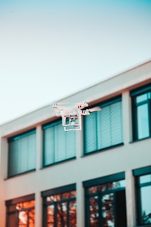 drone flying near building windows for real estate inspection and aerial property assessment