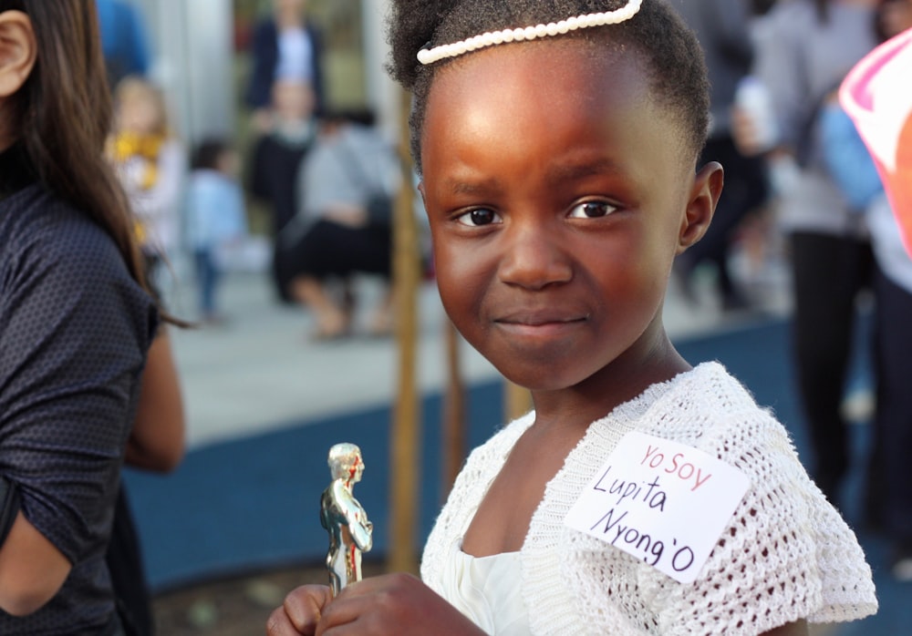 girl holding a silver-colored trophy