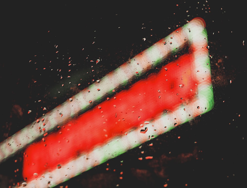 a red and white traffic sign sitting on top of a wet window