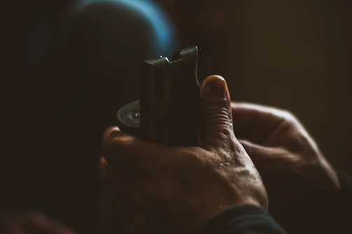 Hands holding a finished wooden portrait with warm lighting.
