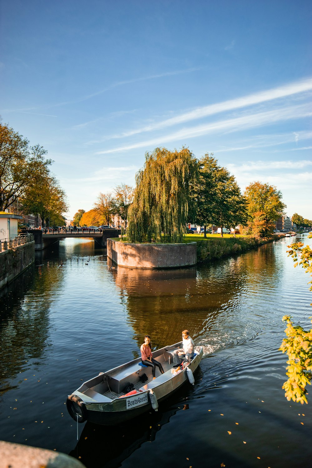 man and woman riding on white boat on body of water at daytime