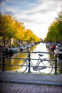 bicycle leaning on railing near river