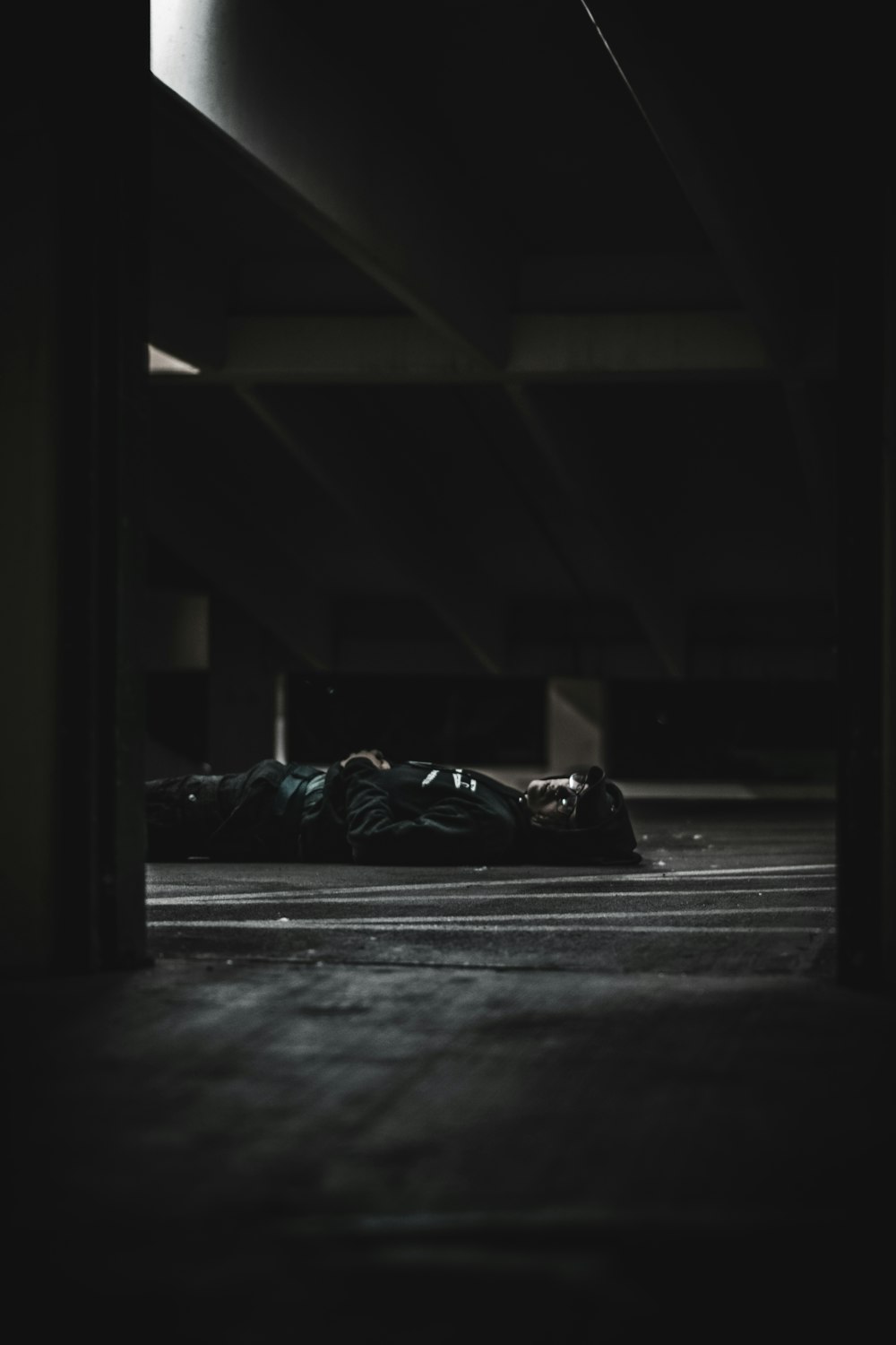 una persona sdraiata sul pavimento in una stanza buia