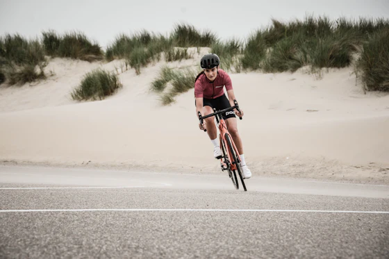 Ciclista pedalando entre dunas de areia
