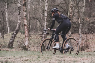 woman riding bicycle near trees