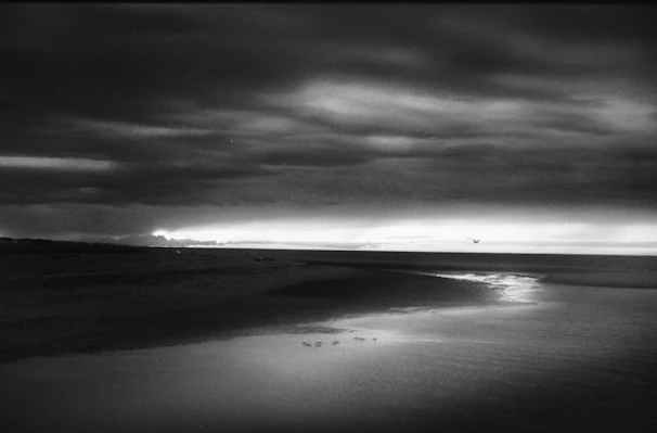 A dramatic monochrome shot of clouds rolling over the ocean at dawn.