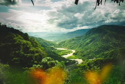 A lush green valley with a winding river under a cloudy sky in Tahiti.