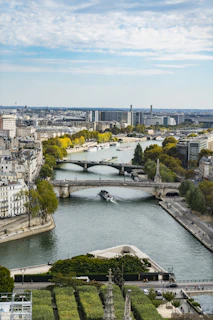 A panoramic shot of a riverside city with boats and bridges connecting neighborhoods.
