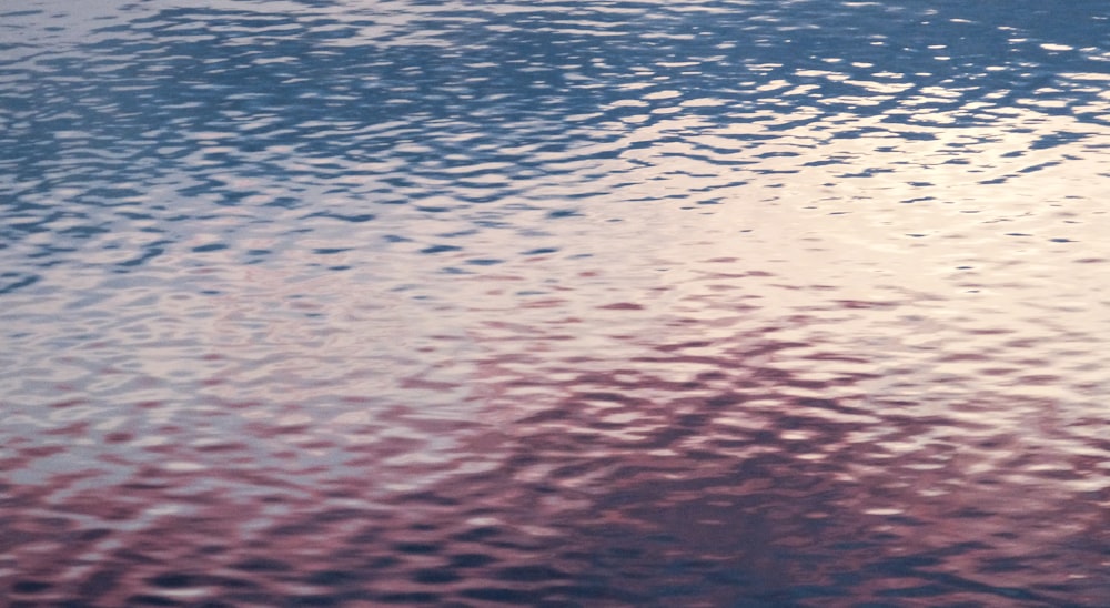 a large body of water with a sky in the background