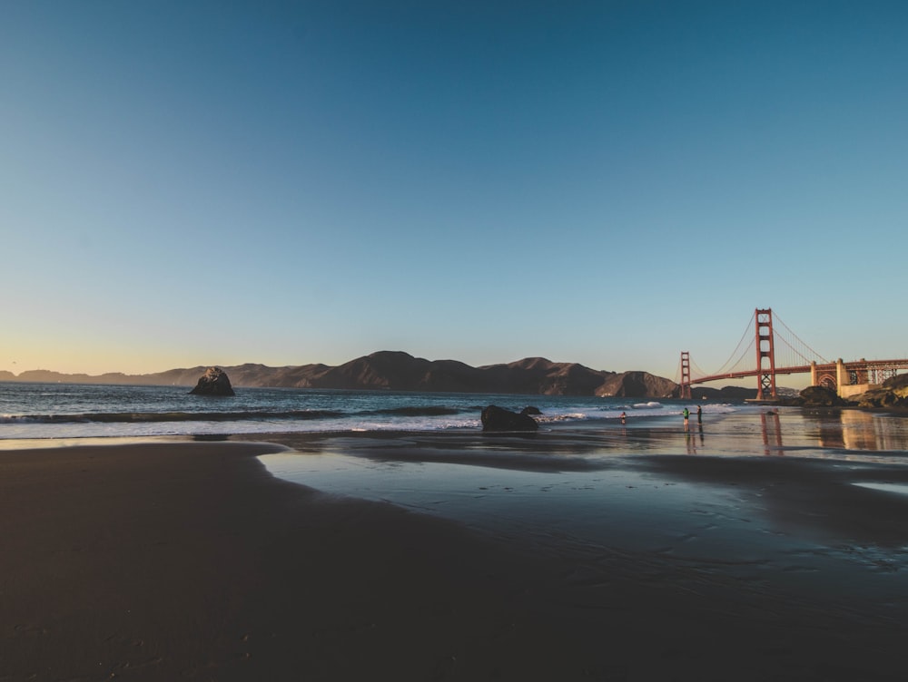 Golden Gate bridge seen from beach under clear blue sky