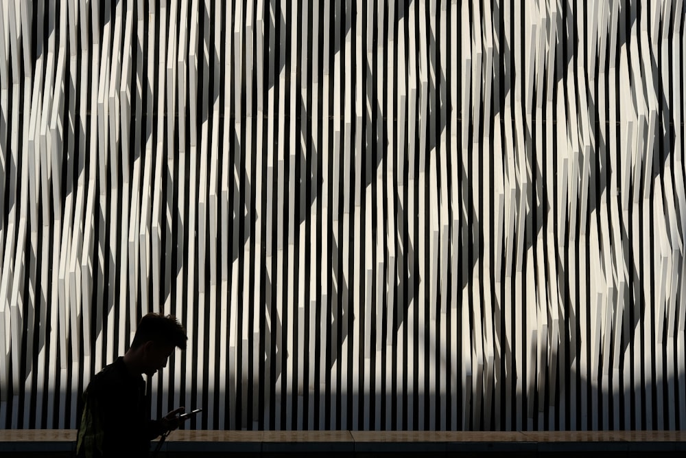 a man walking down a street past a tall building