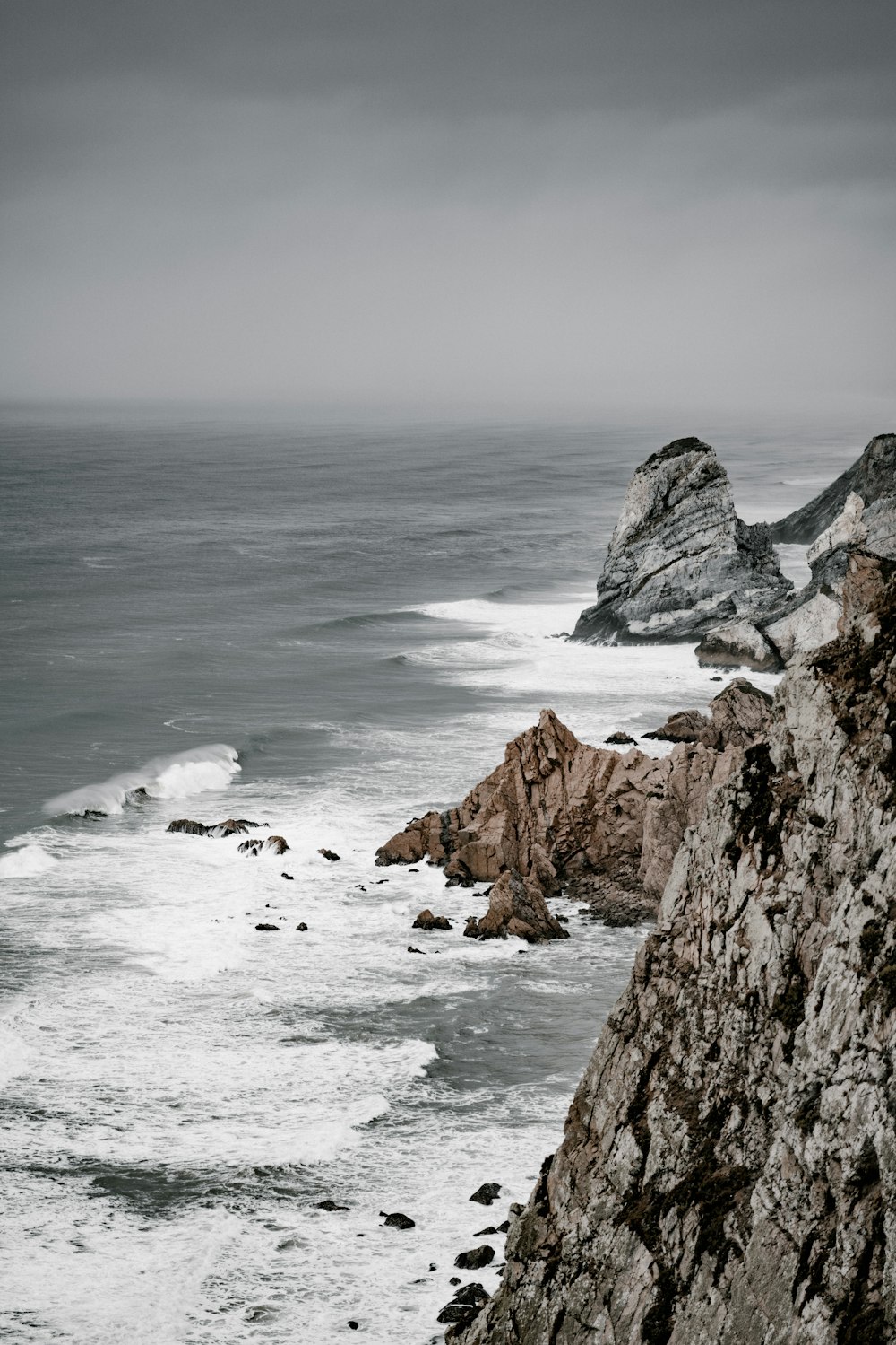 ocean waves and rock island during day