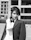 Photo of a confident man in a suit with a construction site in the background.