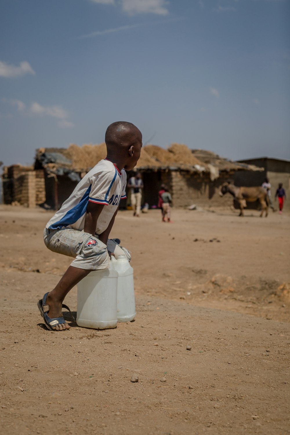 boy holding two white containers during daytime