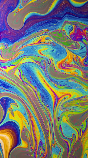A vibrant, swirling tie-dye pattern bursting with bright colors like pink, blue, yellow, and green.