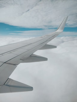aerial photography of airplane wing and clouds