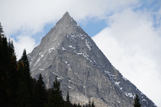 gray mountain under cloudy sky in Siguniang Mountain China