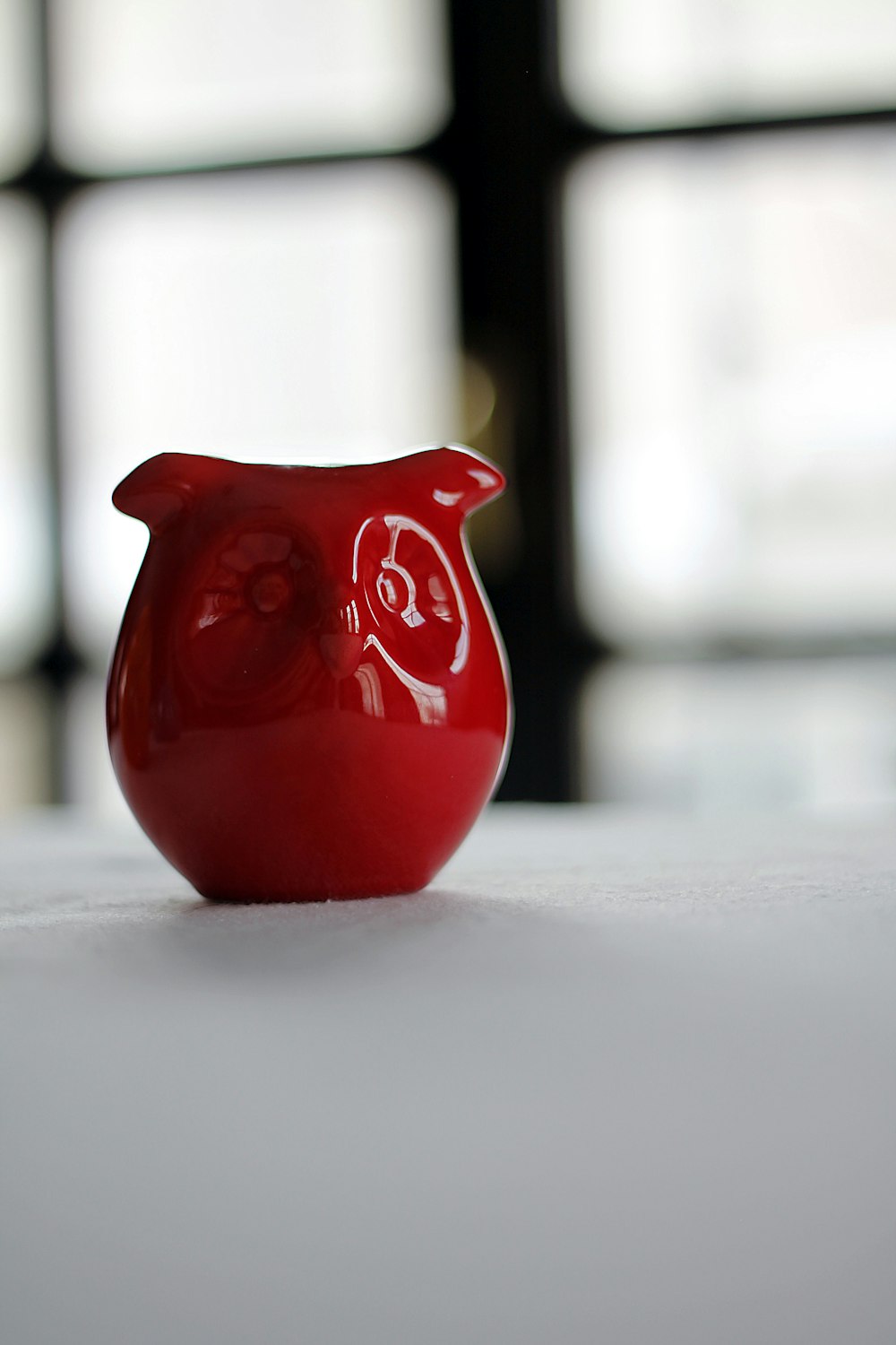 red owl figurine on white surface