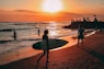 people on beach during sunset ]
