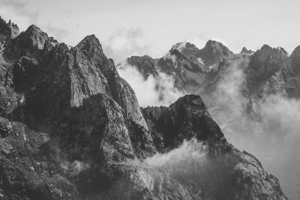 fotografia in scala di grigi della montagna con fumo