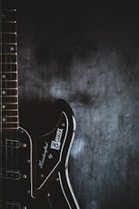 a black electric guitar with a black background