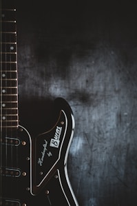 a black electric guitar with a black background