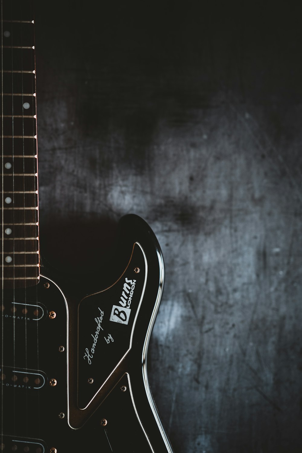 Una chitarra elettrica nera con uno sfondo nero