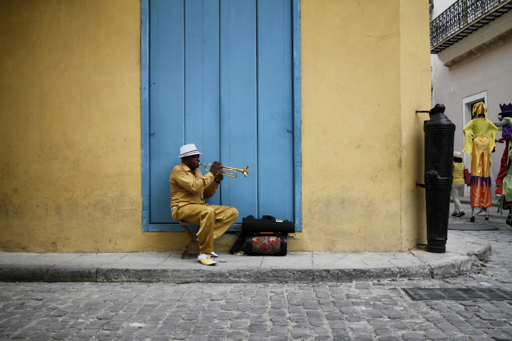 homme assis portant une chemise jaune pendant la journée