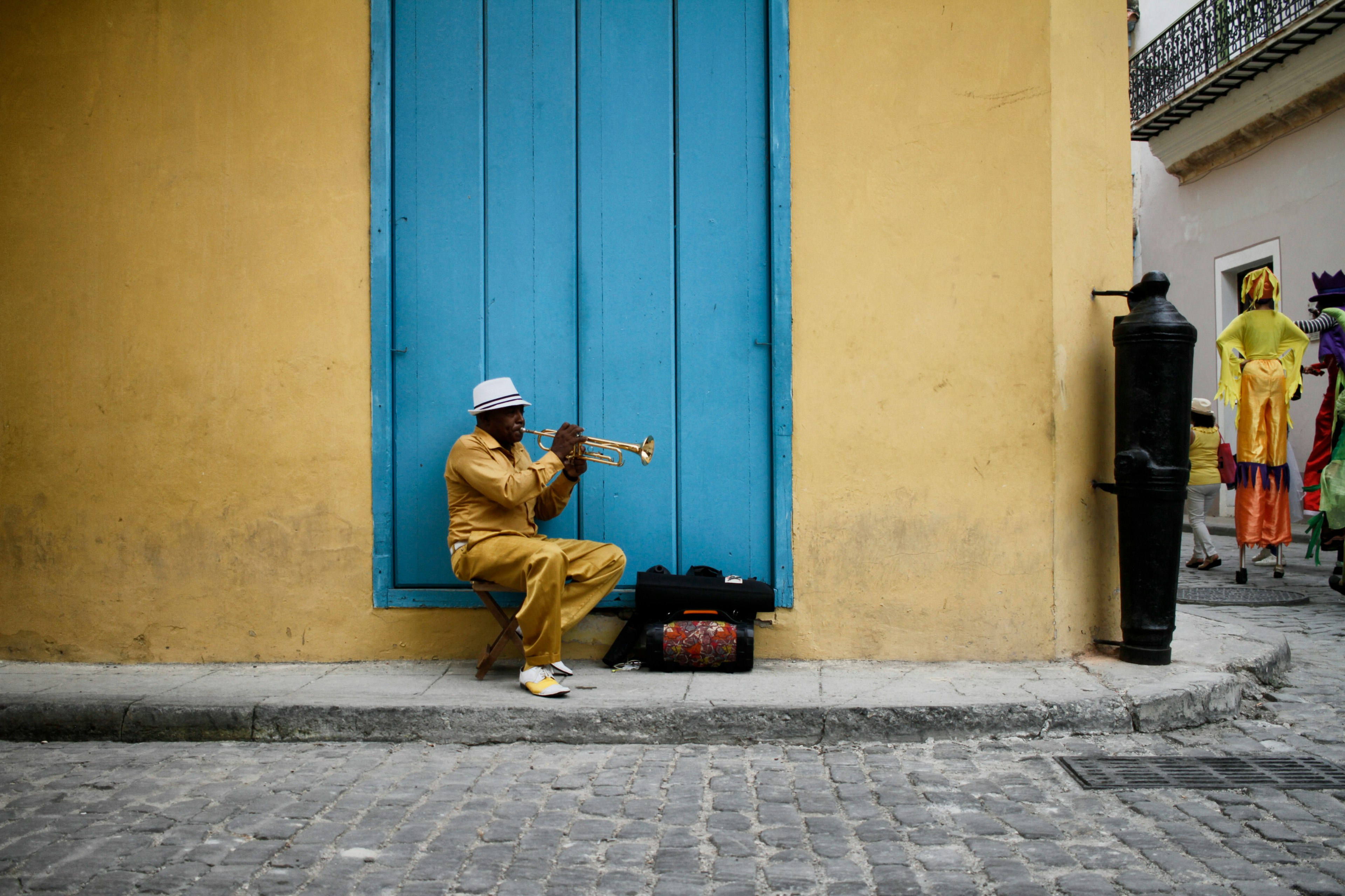 un uomo suona la tromba su una strada colorata de l'havana a cuba
