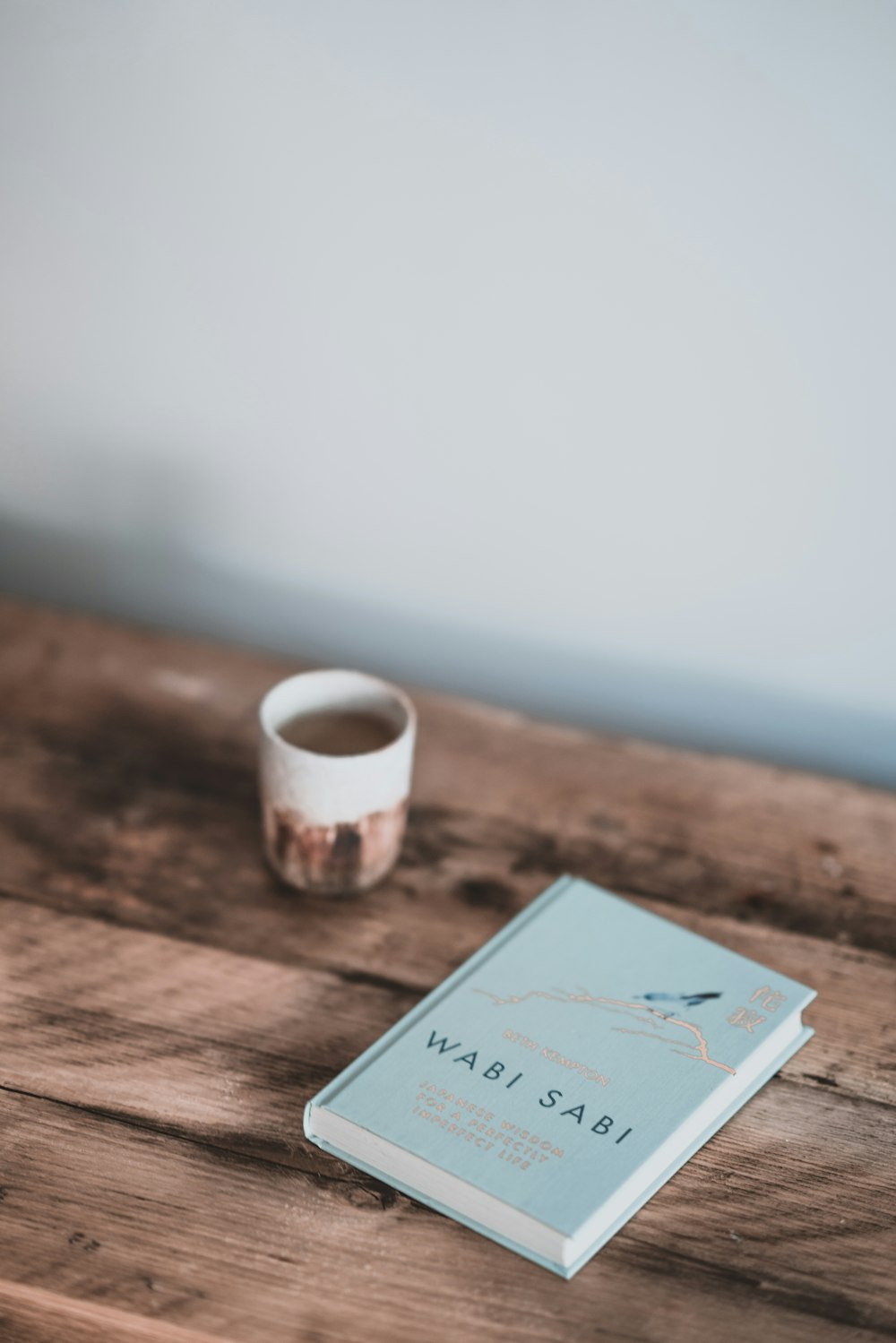 closed Wabi Sabi book on brown wooden surface