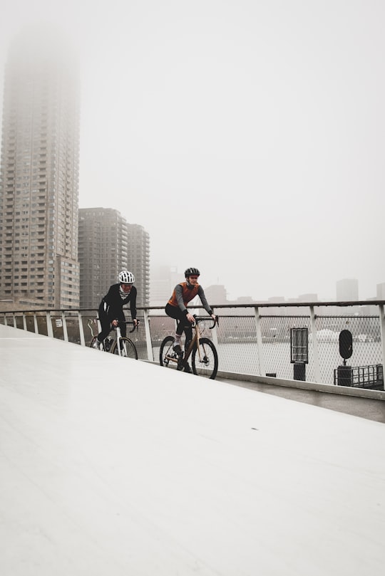 two men riding on bicycle on bridge at daytime in Katendrecht Netherlands