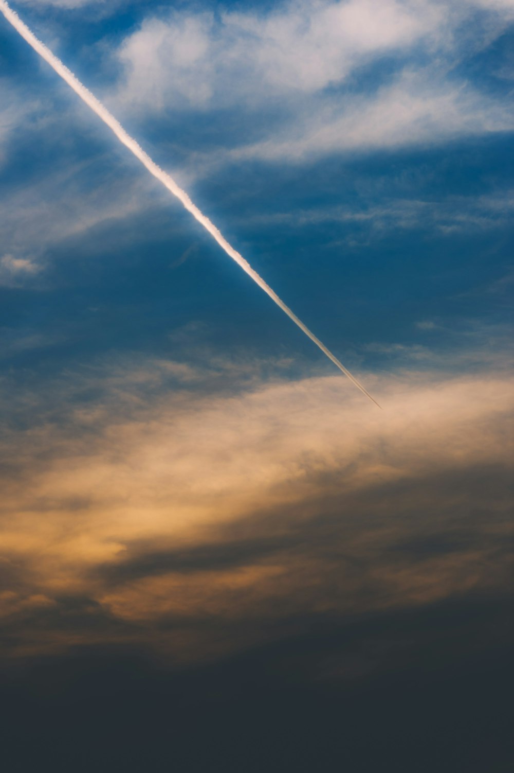 Un avión volando en el cielo con una estela en el cielo