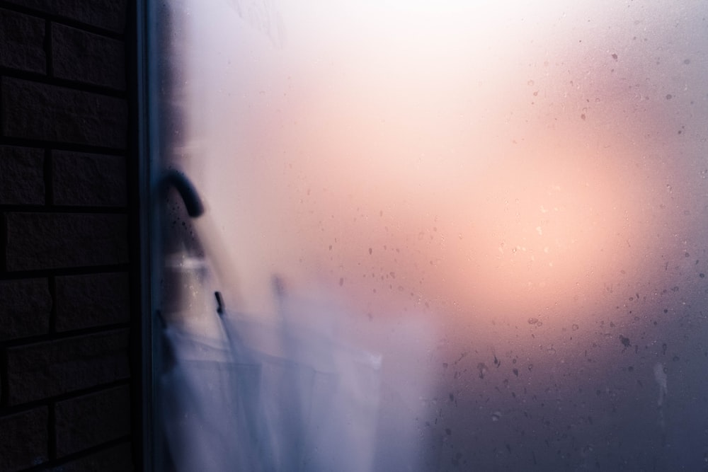 a blurry photo of a window with a brick wall