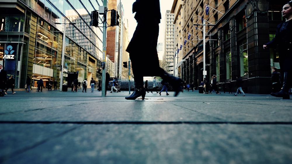 woman in black dress walking on side walk