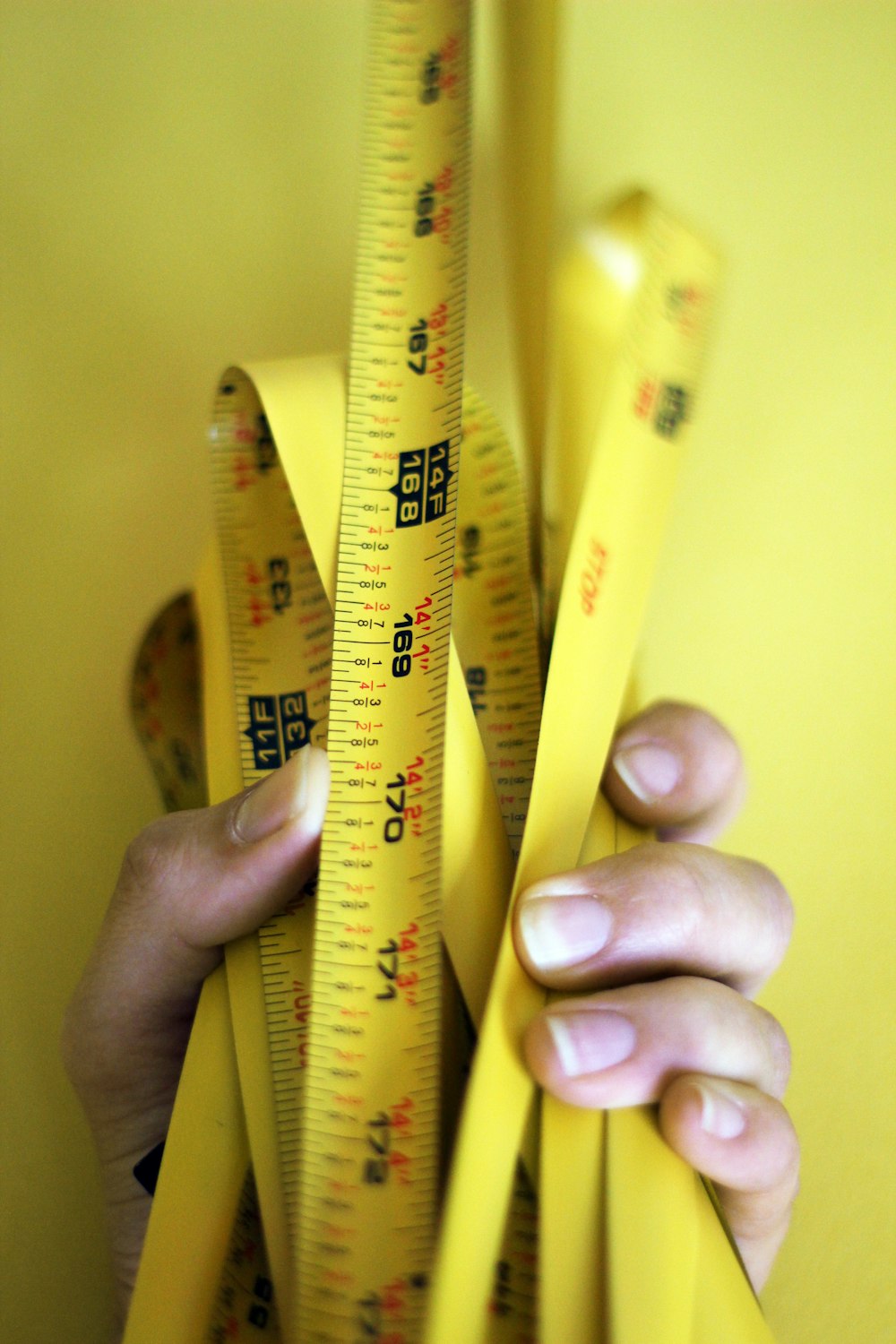 person holding yellow steel tape measure