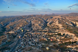 aerial photography of village with hot air balloon flying on sky