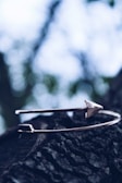 A stylish metal bracelet displayed on a wooden surface.