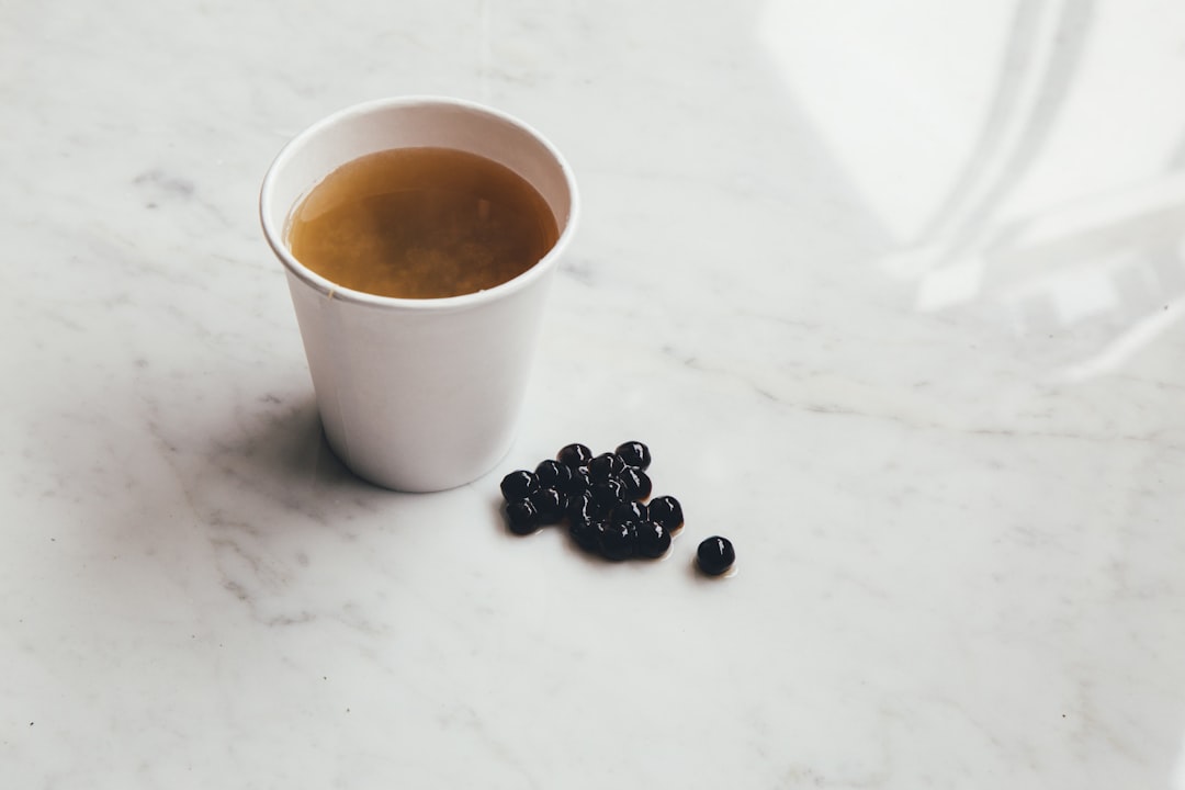 white ceramic mug beside coffee beans