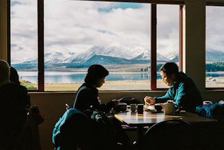 A couple enjoying a romantic candlelit dinner overlooking a luxury mountain resort.