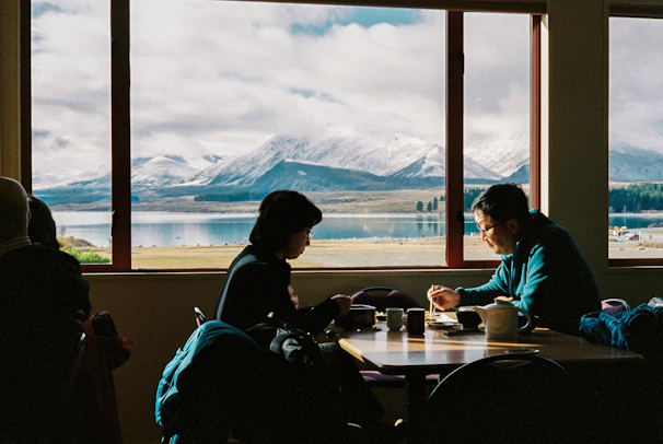 A couple enjoying a romantic candlelit dinner overlooking a luxury mountain resort.