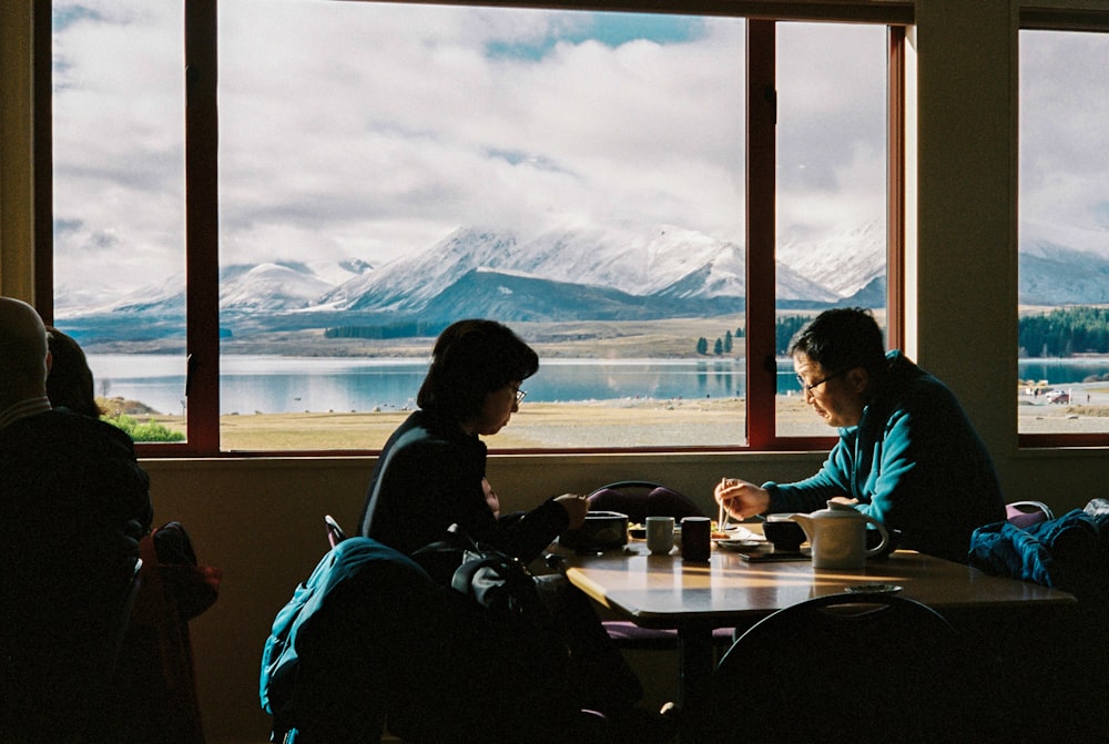 man an woman having breakfast with the view of mountain