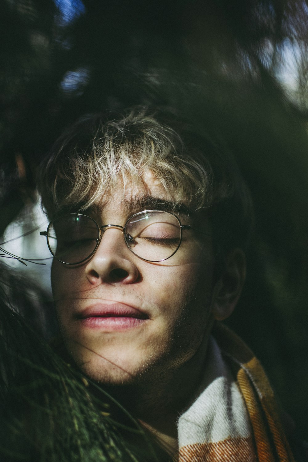 man closing eyes wearing grey framed eyeglasses