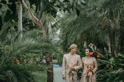 couple walking near the green plant