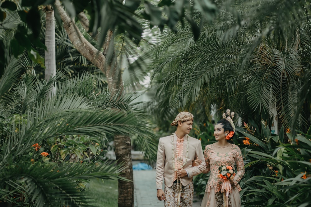 couple walking near the green plant