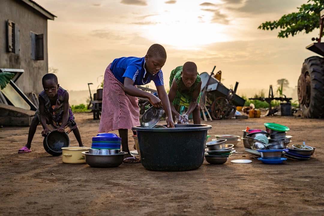 children washing dishes outside