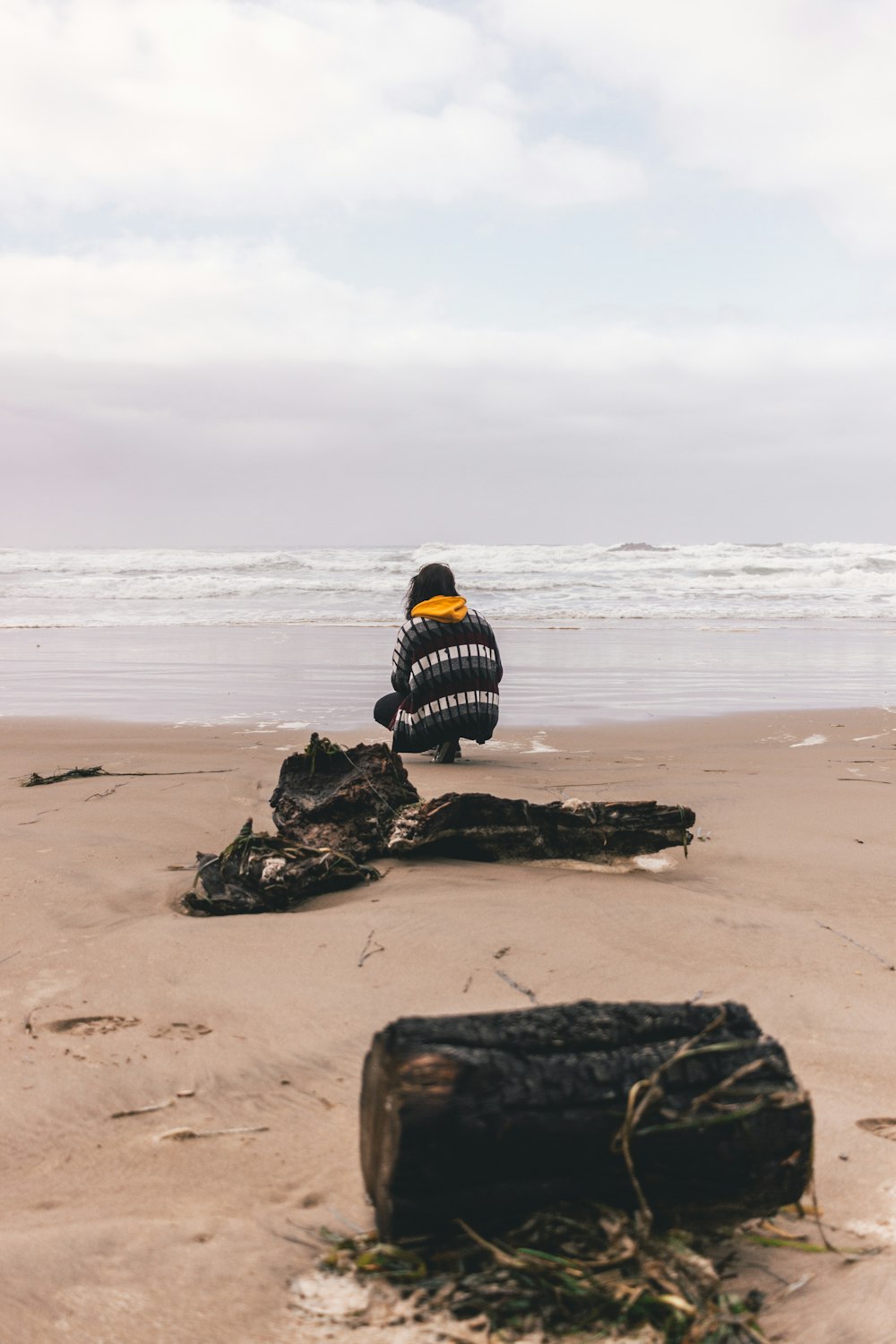 person kneeling on seashore