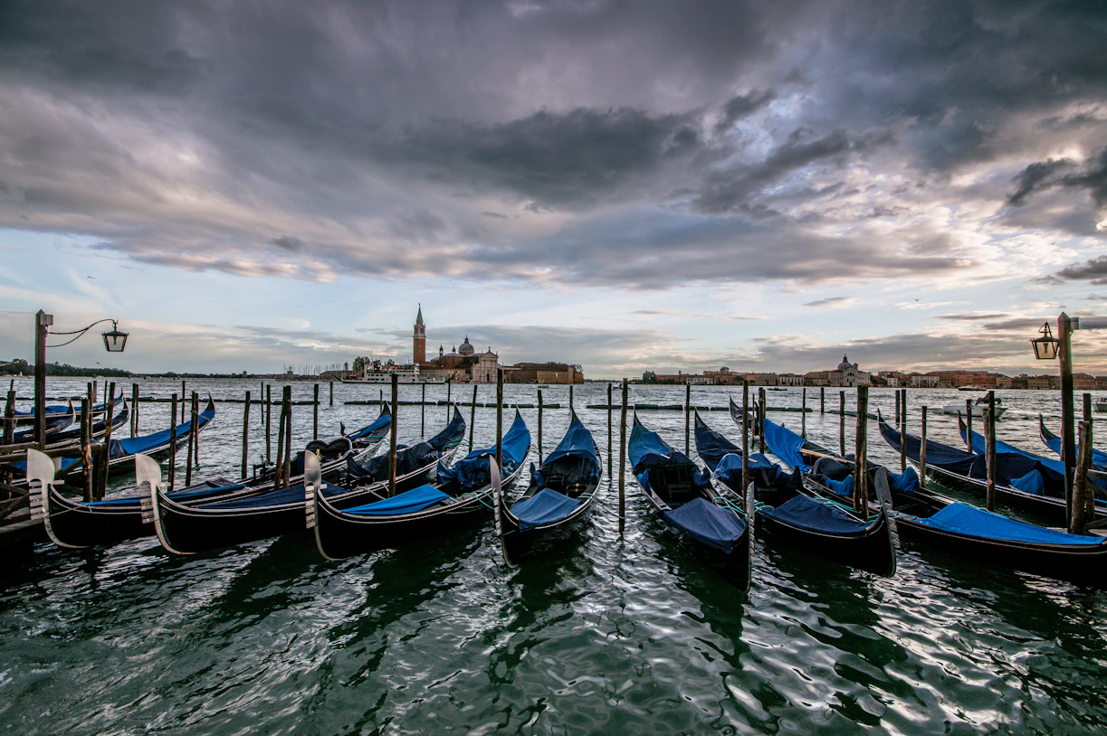 Venice, parked blue boats beside dock