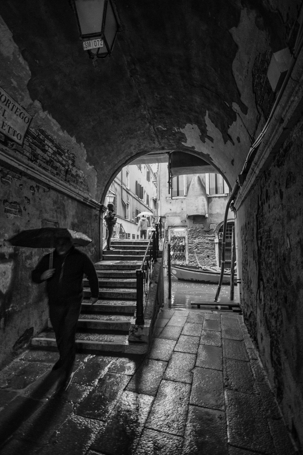 man with umbrella walking in tunnel