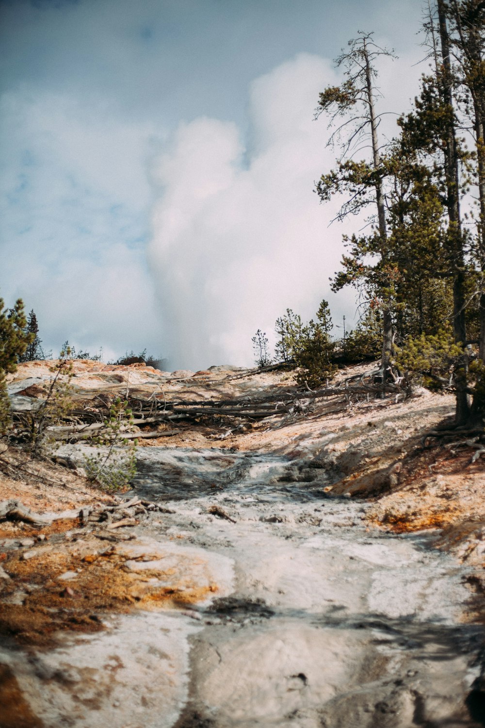 white clouds over steep rock slope